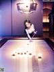 A woman is playing pool in a room.