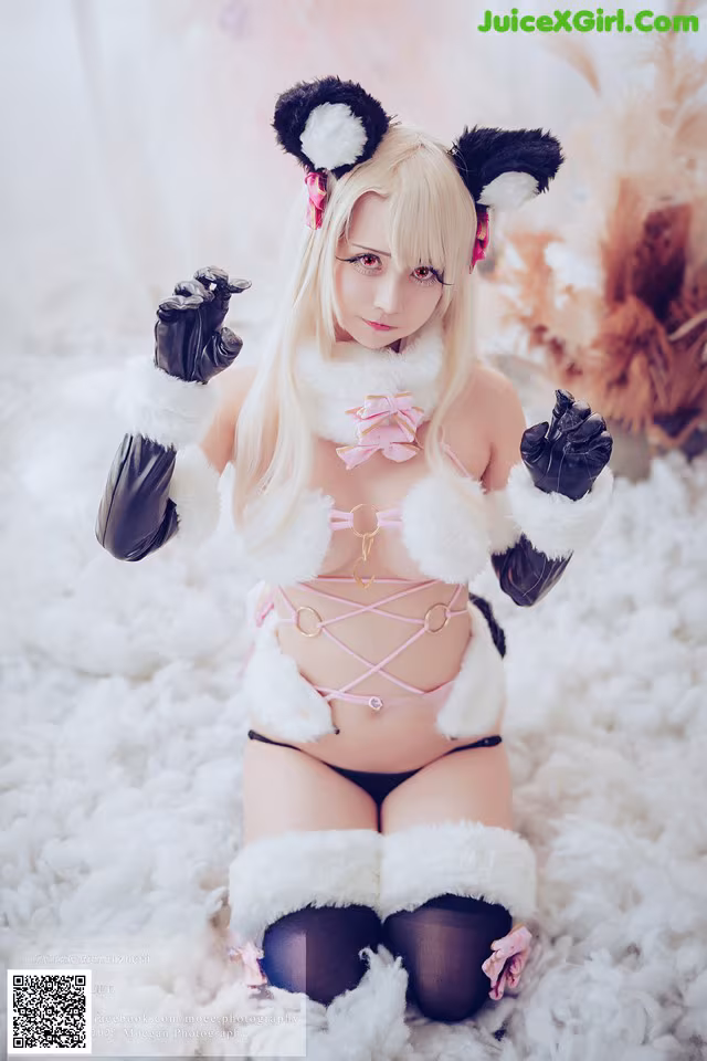 A woman in a pink bikini and black gloves posing for a picture.