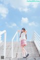 A woman in a school uniform is standing on some stairs.