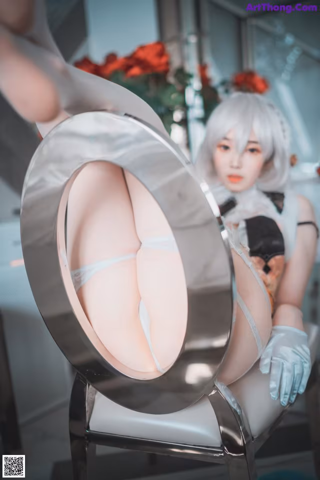 A woman sitting on a chair in front of a mirror.