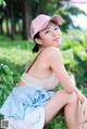 A woman in a pink hat sitting on the ground.