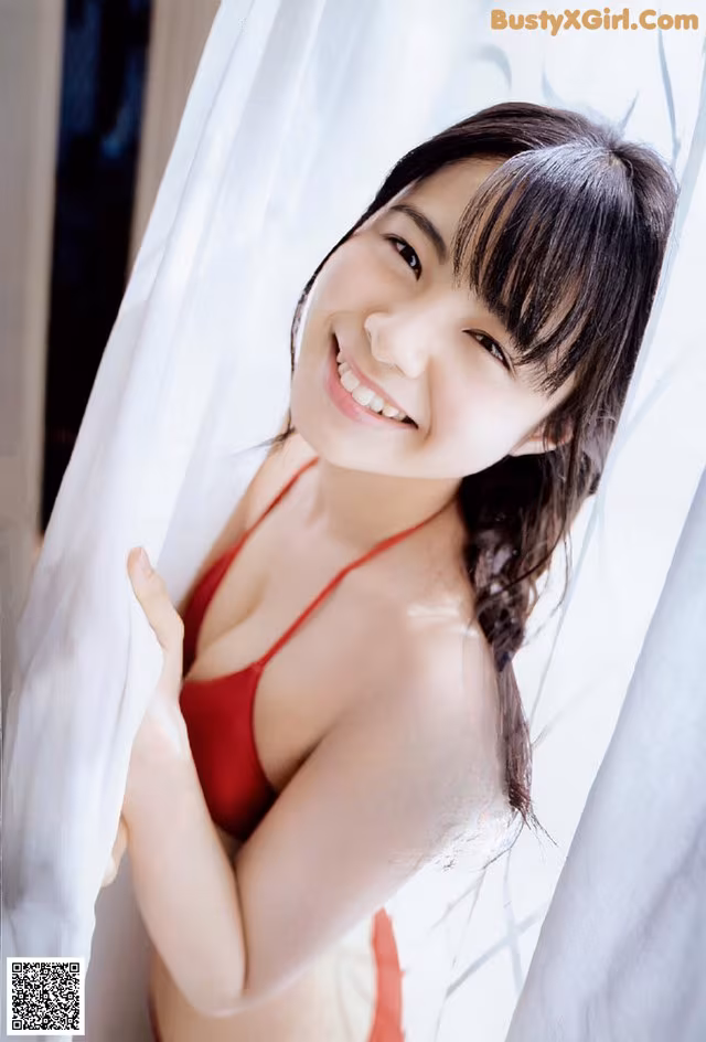 A woman in a red bikini posing for a picture.