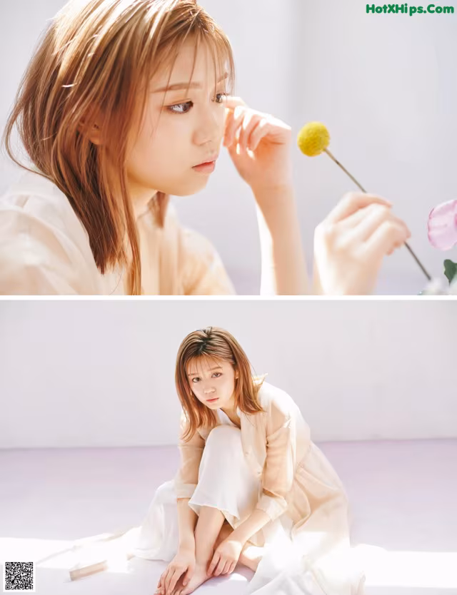 A woman sitting on the floor holding a flower in her hand.