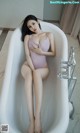 a woman sitting in a bathtub with her legs crossed